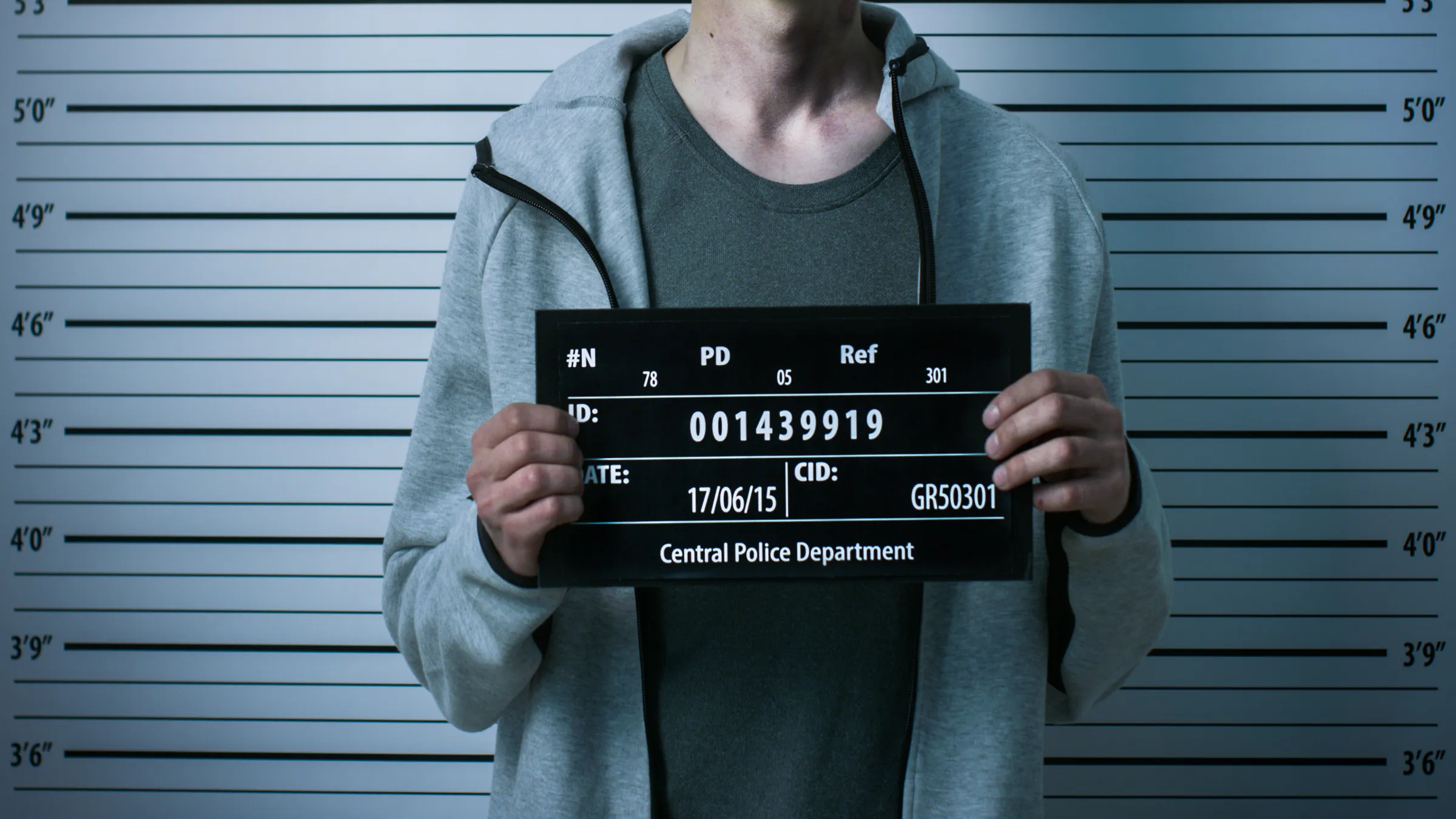hands holding mugshot board